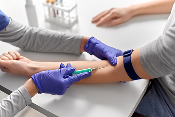 Image showing doctor taking blood for test from patient's hand