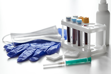 Image showing beakers with blood tests, syringe, gloves and mask