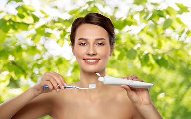 Image showing smiling woman with toothbrush cleaning teeth