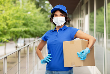 Image showing delivery woman in face mask holding parcel box