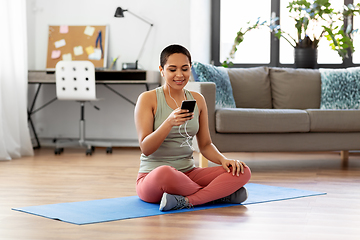 Image showing woman with earphones and smartphone doing sports