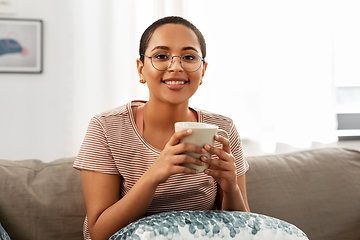 Image showing happy african woman drinking tea or coffee at home