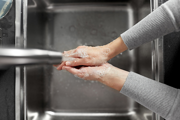 Image showing woman washing hands with soap in kitchen