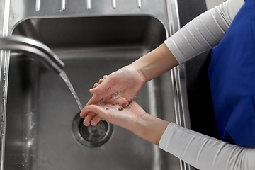 Image showing doctor or nurse washing hands with liquid soap