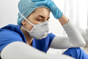 Image showing sad doctor or nurse in face mask holding to head