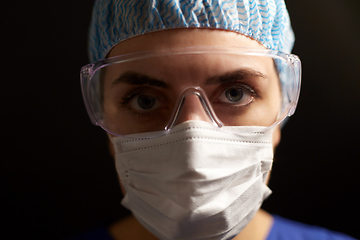 Image showing female doctor or nurse in goggles and face mask