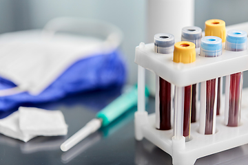 Image showing beakers with blood tests, syringe, gloves and mask