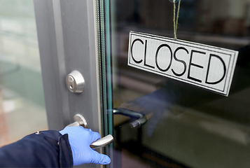 Image showing hand in medical glove holding to closed door