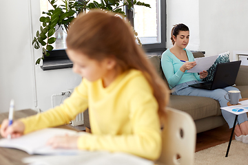 Image showing mother working and daughter studying at home