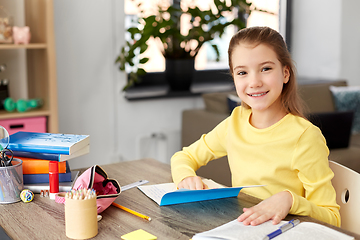 Image showing student girl with book and notebook at home