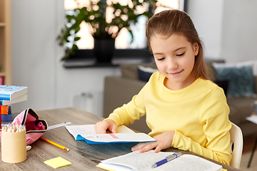 Image showing student girl with book and notebook at home