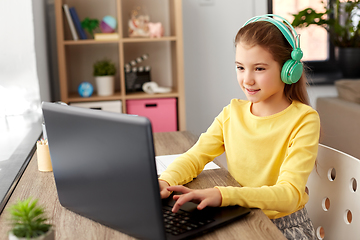 Image showing girl in headphones with laptop computer at home