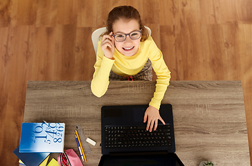 Image showing smiling student girl typing on laptop at home