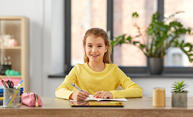 Image showing student girl writing to notebook at home