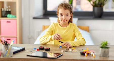 Image showing happy girl playing with robotics kit at home