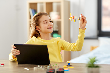 Image showing girl with tablet pc and robotics kit at home