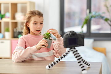 Image showing girl with camera and flower video blogging at home