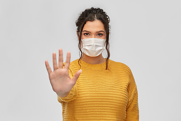 Image showing woman in medical mask making stop gesture