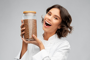 Image showing happy female chef with buckwheat in glass jar