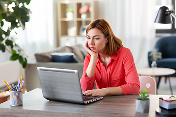 Image showing bored woman with laptop working at home office