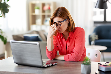 Image showing bored woman with laptop working at home office