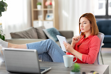 Image showing sad woman with notebook and laptop at home office