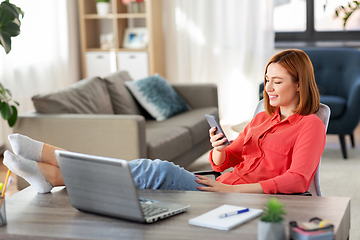 Image showing woman with smartphone and laptop at home office