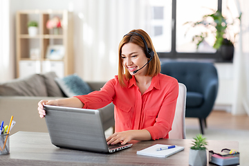 Image showing woman with headset and laptop working at home