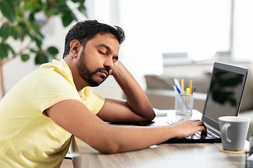 Image showing indian man sleeping on table with laptop at home