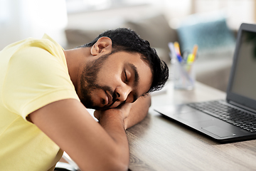 Image showing indian man sleeping on table with laptop at home