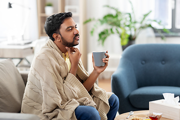 Image showing sick man with tea touching his sore throat at home