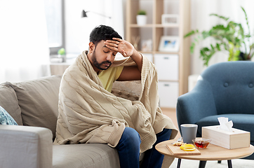 Image showing sick young man in blanket having headache or fever