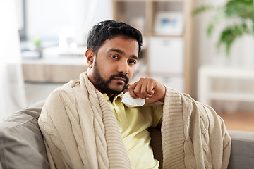 Image showing sick man in blanket with paper tissue at home