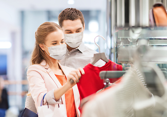 Image showing couple in medical masks with shopping bags in mall