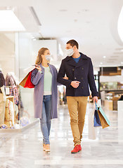 Image showing couple in medical masks with shopping bags in mall