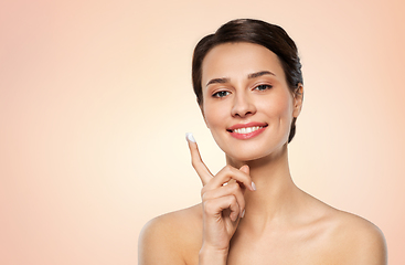 Image showing young woman with moisturizing cream on finger