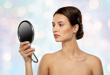 Image showing beautiful young woman looking to mirror