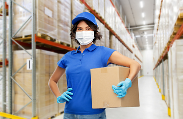 Image showing delivery woman in face mask holding parcel box