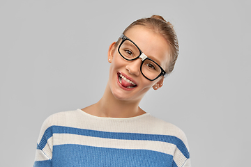 Image showing teenage student girl in glasses showing tongue