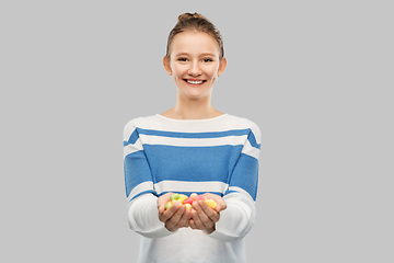 Image showing happy smiling teenage girl holding candies