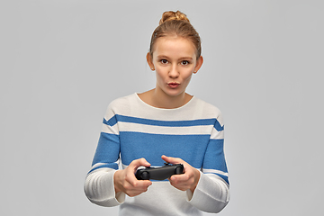 Image showing happy teenage girl with gamepad playing video game