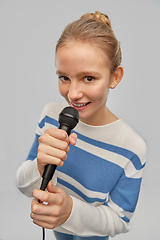 Image showing smiling teenage girl with microphone singing