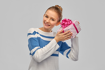 Image showing smiling teenage girl in pullover with gift box