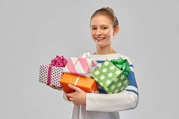 Image showing smiling teenage girl in pullover with gift box