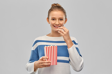 Image showing smiling teenage girl eating popcorn