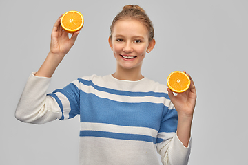 Image showing smiling teenage girl in pullover with oranges