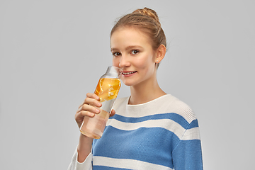 Image showing teenage girl with glass bottle of fruit water