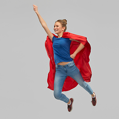 Image showing smiling teenage girl in red superhero cape jumping