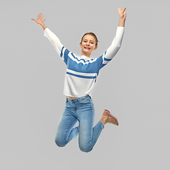 Image showing smiling teenage girl in pullover jumping