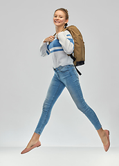 Image showing happy teenage student girl with school bag jumping